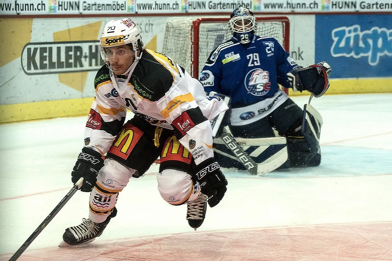 Ishockeyspiller i aktion foran en målmand
